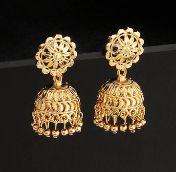 A pair of intricately designed gold-plated jhumka earrings from the Mekkna brand, featuring detailed craftsmanship and a luxurious finish.