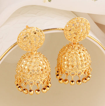 A pair of intricately designed gold-plated jhumka earrings from the Mekkna brand, featuring detailed craftsmanship and a luxurious finish.