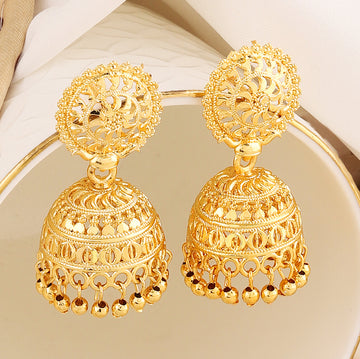 A pair of intricately designed gold-plated jhumka earrings from the Mekkna brand, featuring detailed craftsmanship and a luxurious finish.