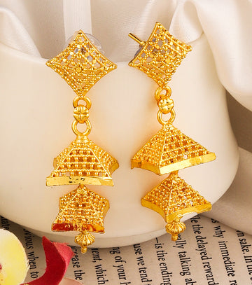 A pair of intricately designed gold-plated jhumka earrings from the Mekkna brand, featuring detailed craftsmanship and a luxurious finish.